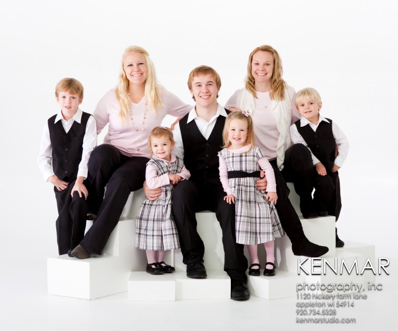 Family of 7 in pastel colors on white background