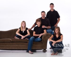 Family posing on a couch in a studio
