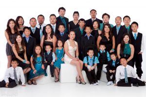 A family of 30 poses comfortably against a white background