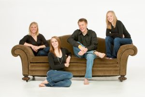 Family of 4 brothers and sisters in a casual, contemporary modern arrangement on a couch.