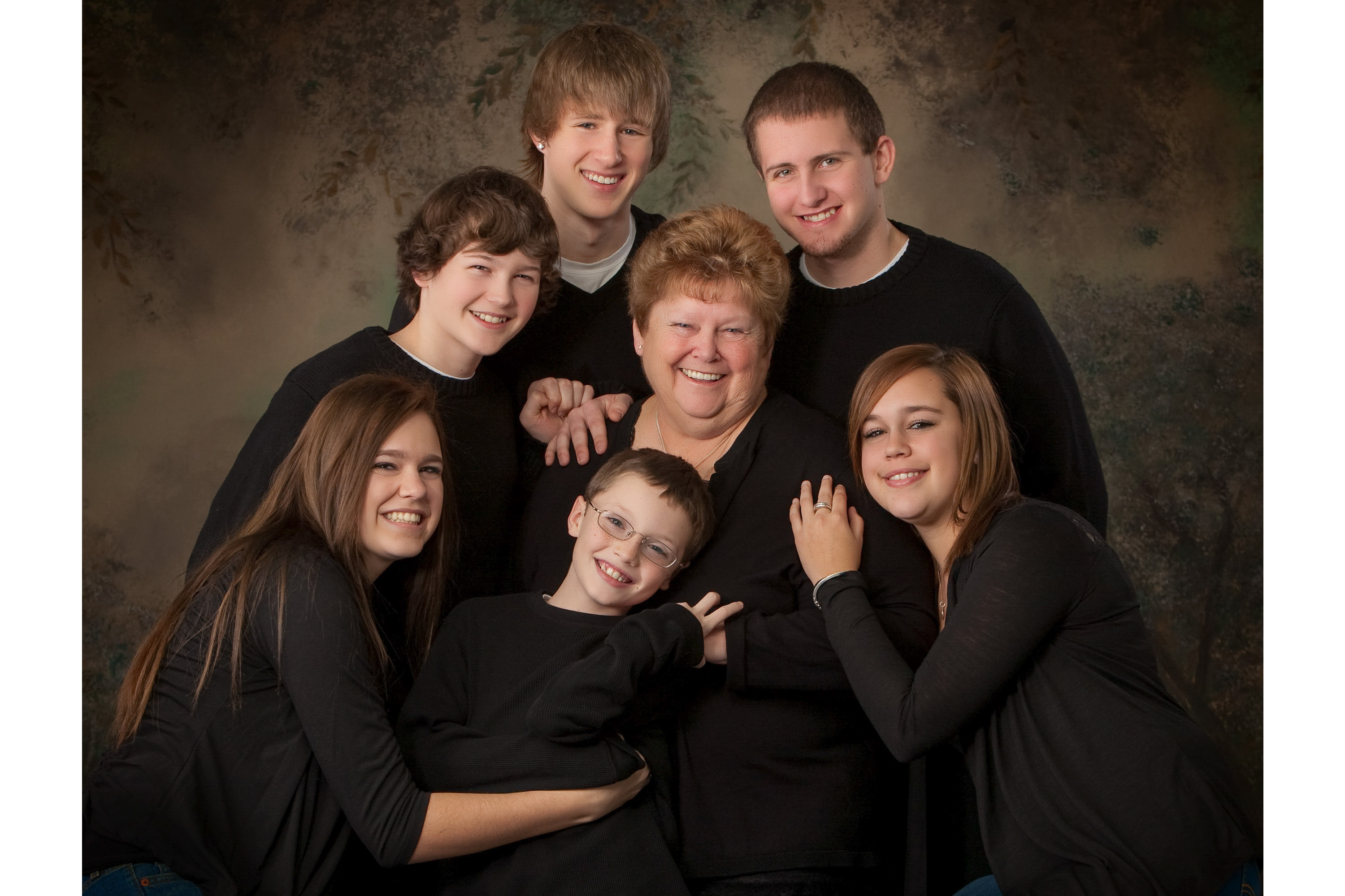 A family of 7 siblings, brothers and sisters and mom beautifully posed in coordinated outfits makes for a priceless, timeless heirloom portrait