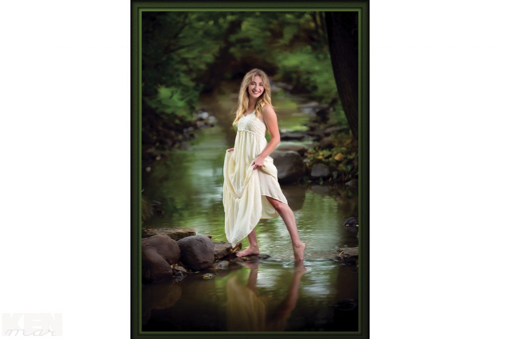 Young woman posed outdoors by stream KenMar / 1120 North Hickory Farm Lane / Appleton, WI 54914 / 920-734-5328