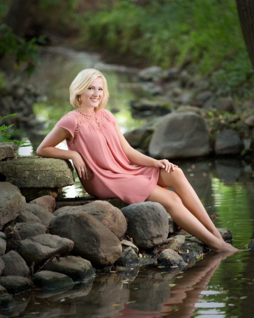 Young woman posed outdoors by stream